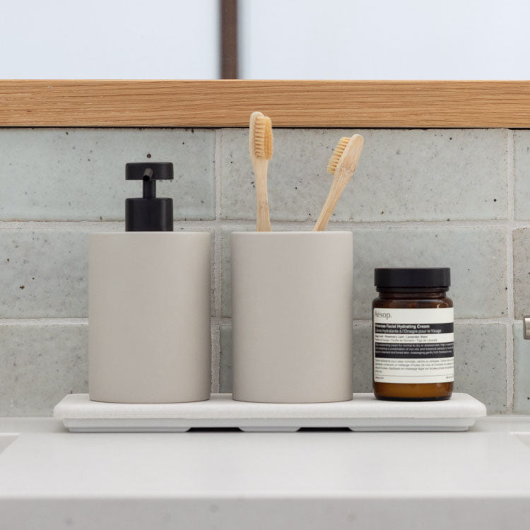 concrete brush holder and soap dispenser on top of quick drying stone sink caddy