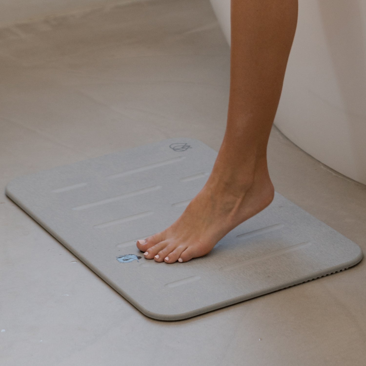 foot stepping onto rain bath stone - ash color - Dorai Home