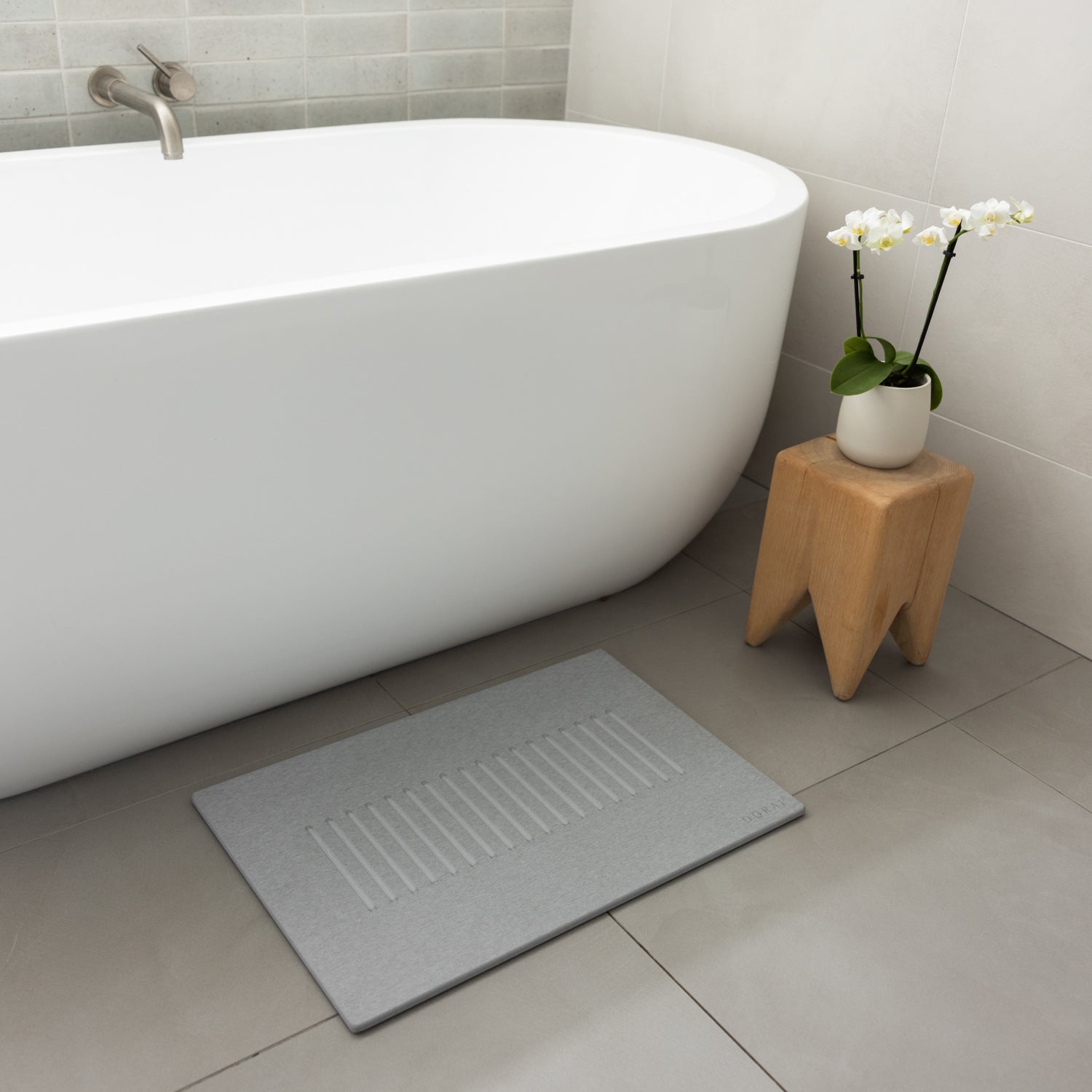 light gray shower mat in front of tub