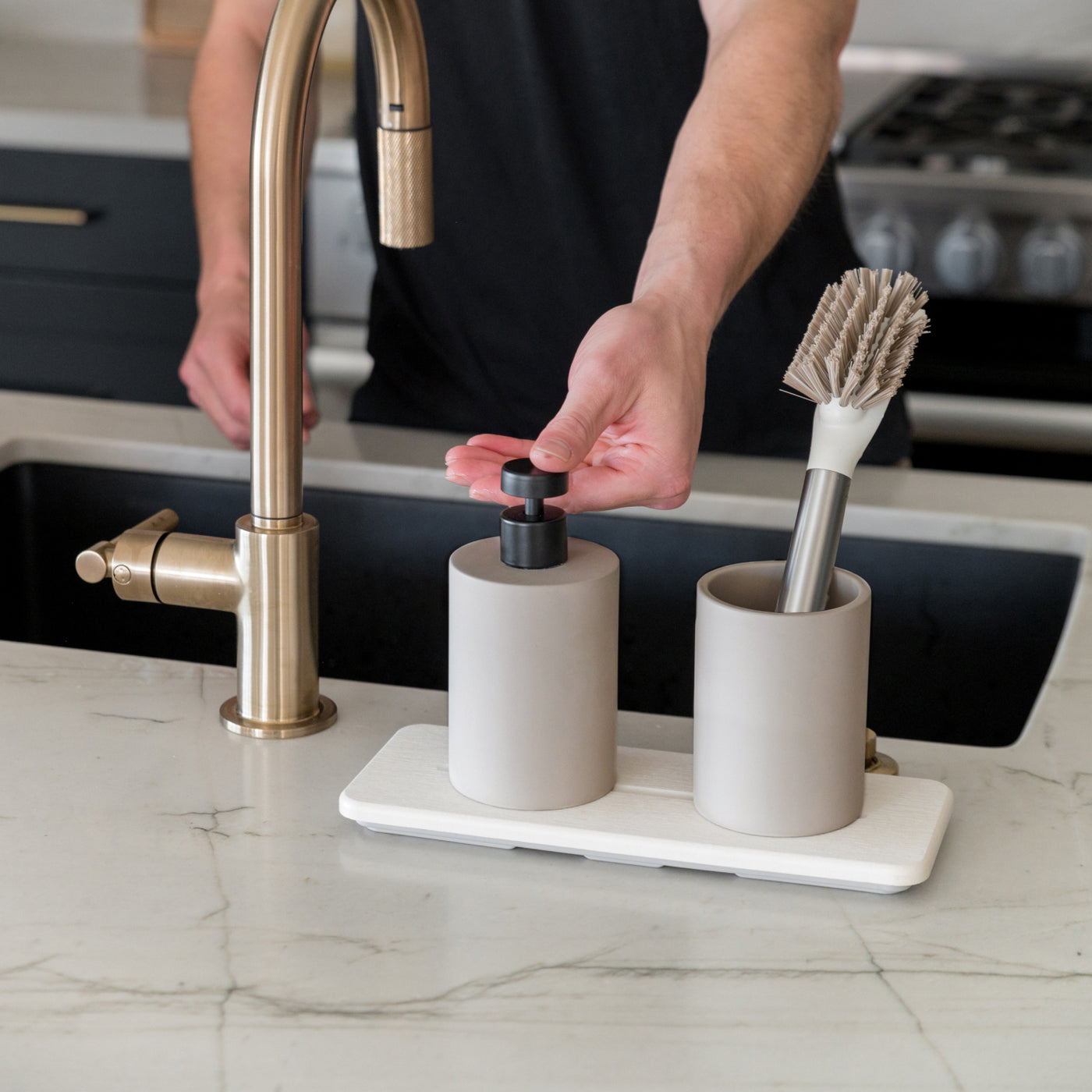 modern stone sink caddy in kitchen with person pumping the soap - Dorai Home
