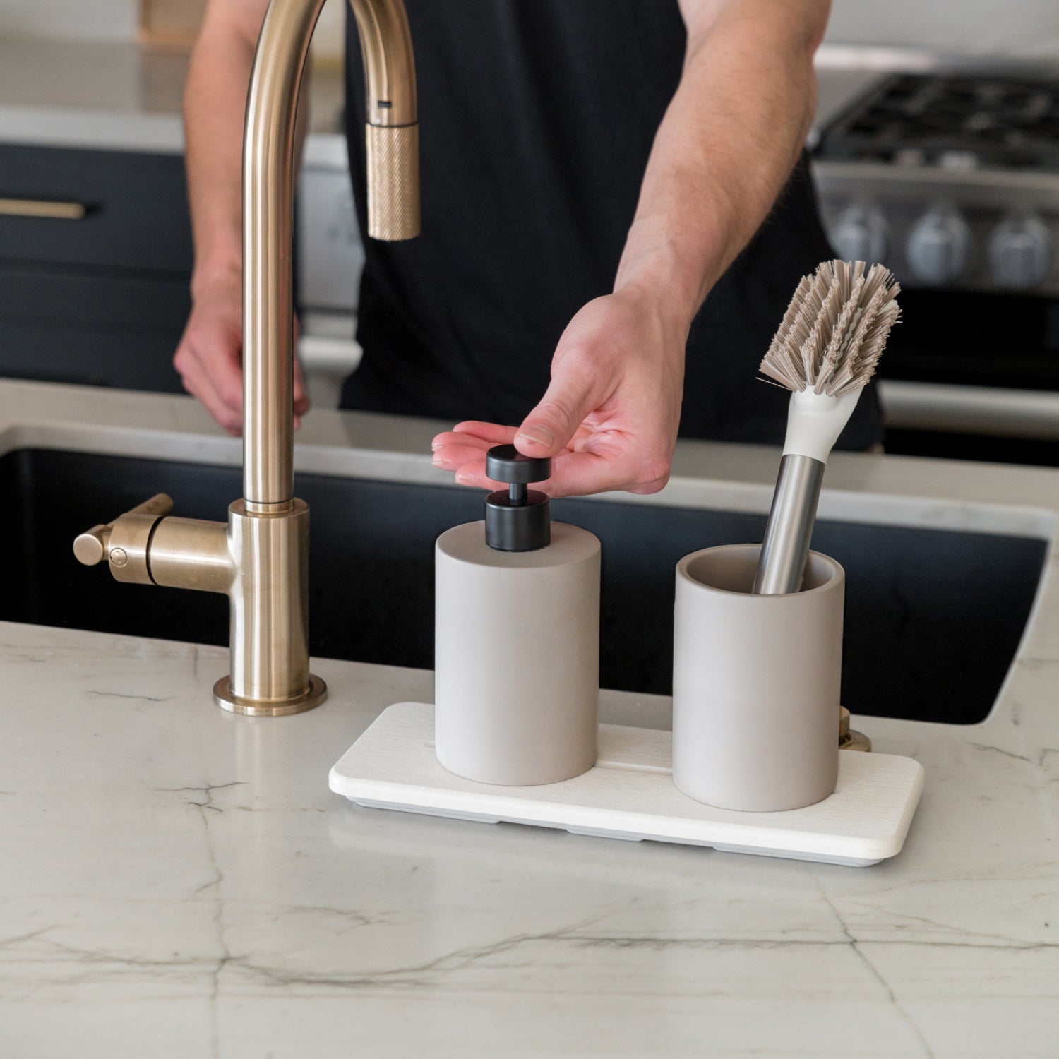 modern stone sink caddy in kitchen with person pumping the soap - Dorai Home
