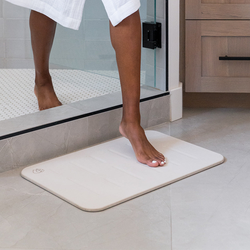 person stepping on bath stone in bathroom