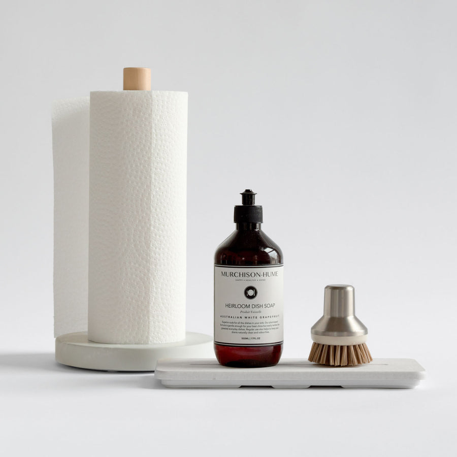 dish soap bottle with paper towel holder and brush on a white surface