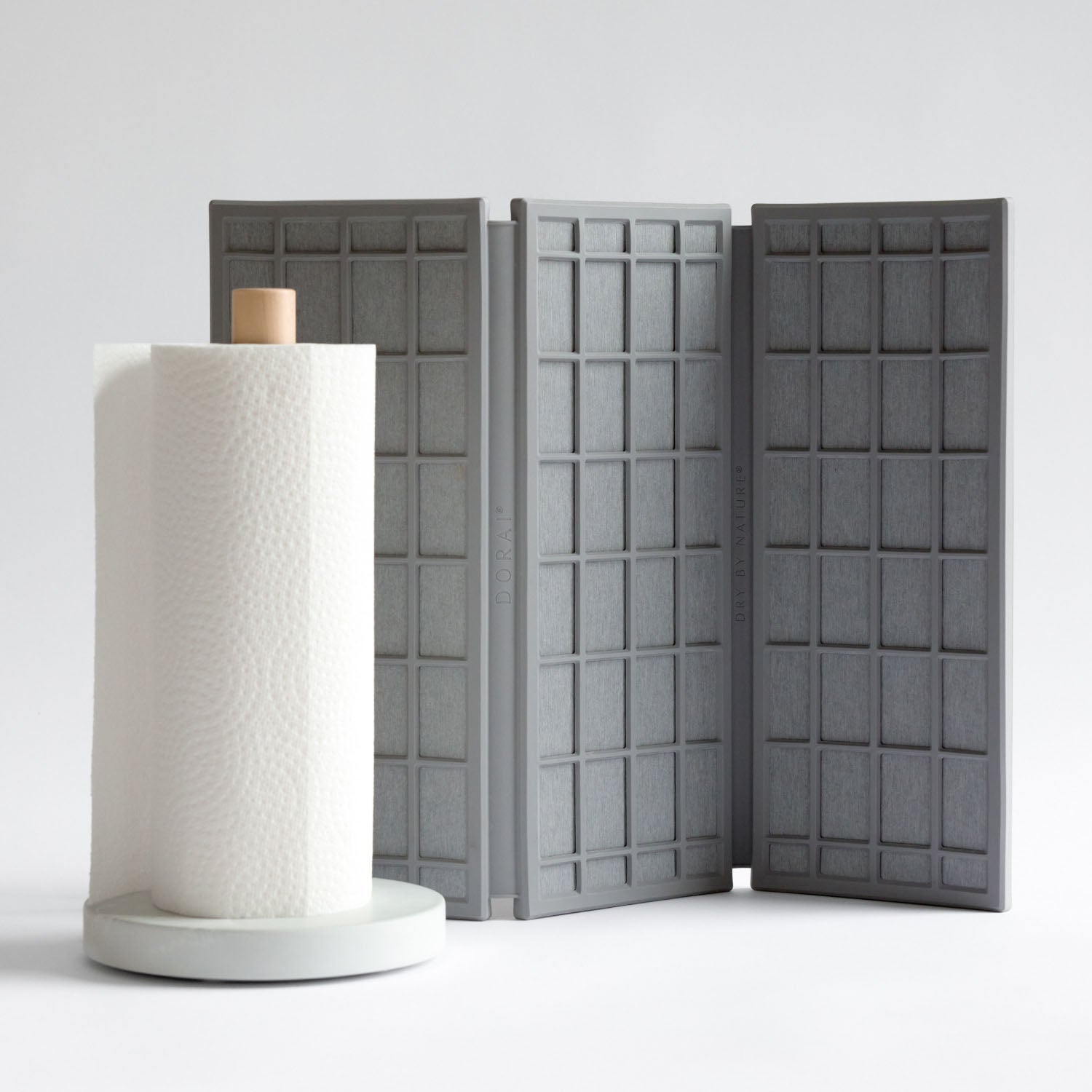Gray modular dish pad with a white paper towel holder on a light gray background