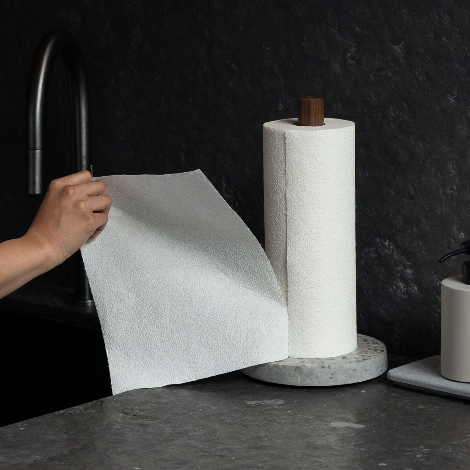 Ripping Basalt Paper Towel Holder with one hand in beautiful kitchen. 