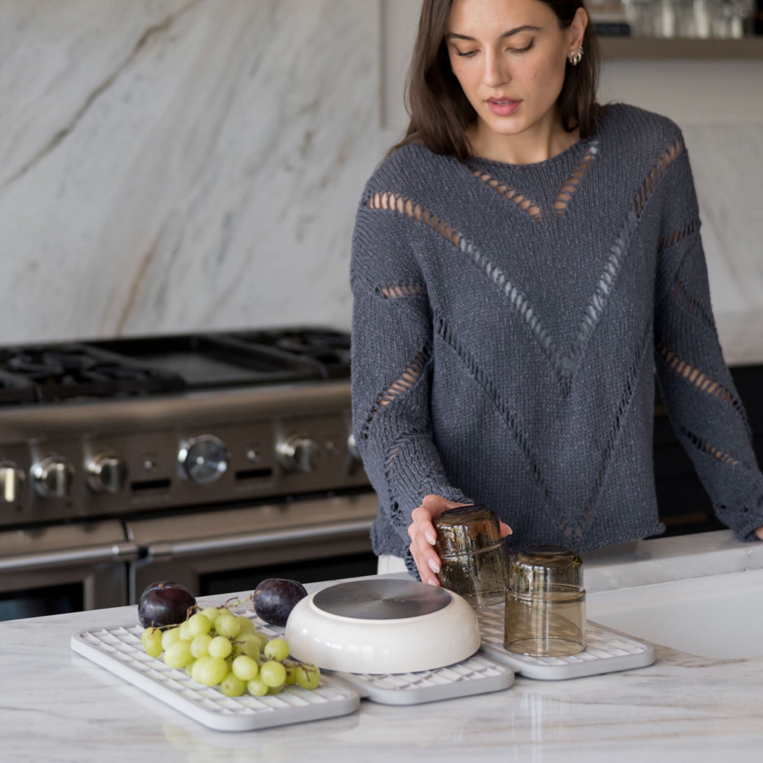 woman putting dishes on dish pad in kitchen - Dorai Home