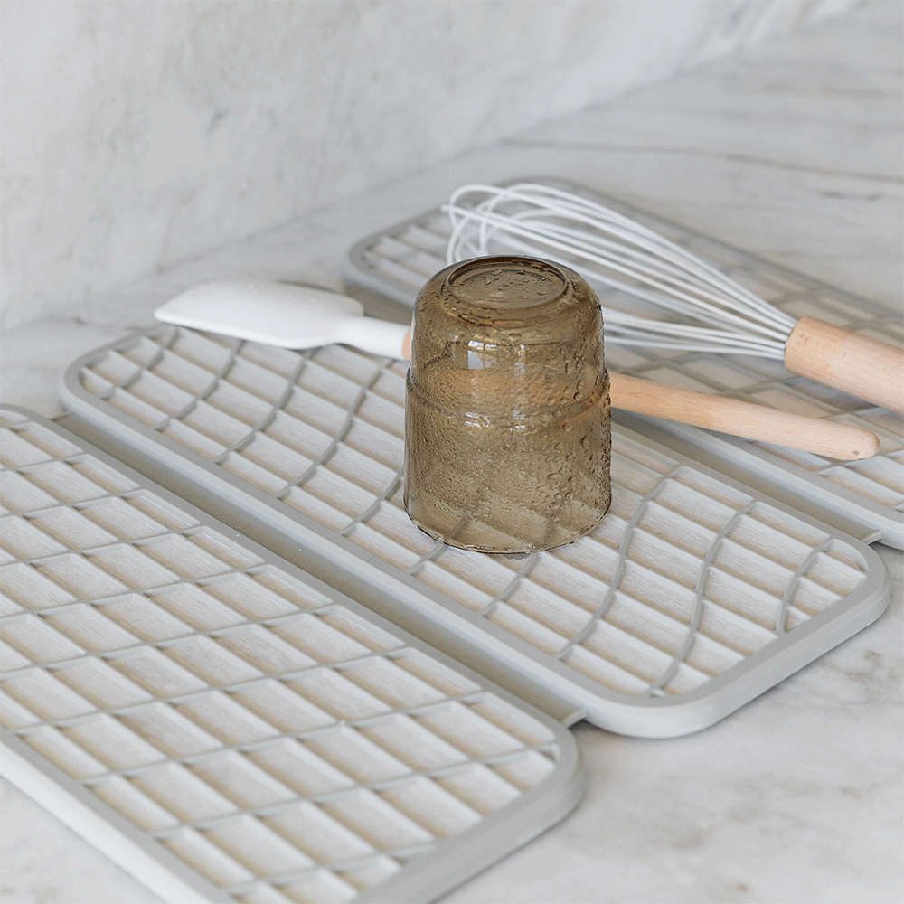 glass being put on quick-drying stone dish drying mat