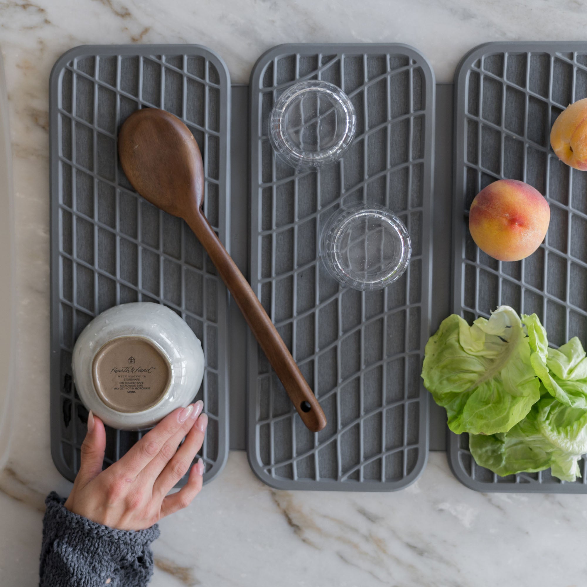 Drift Slate Dish Pad with produce, utensils, and glasses.