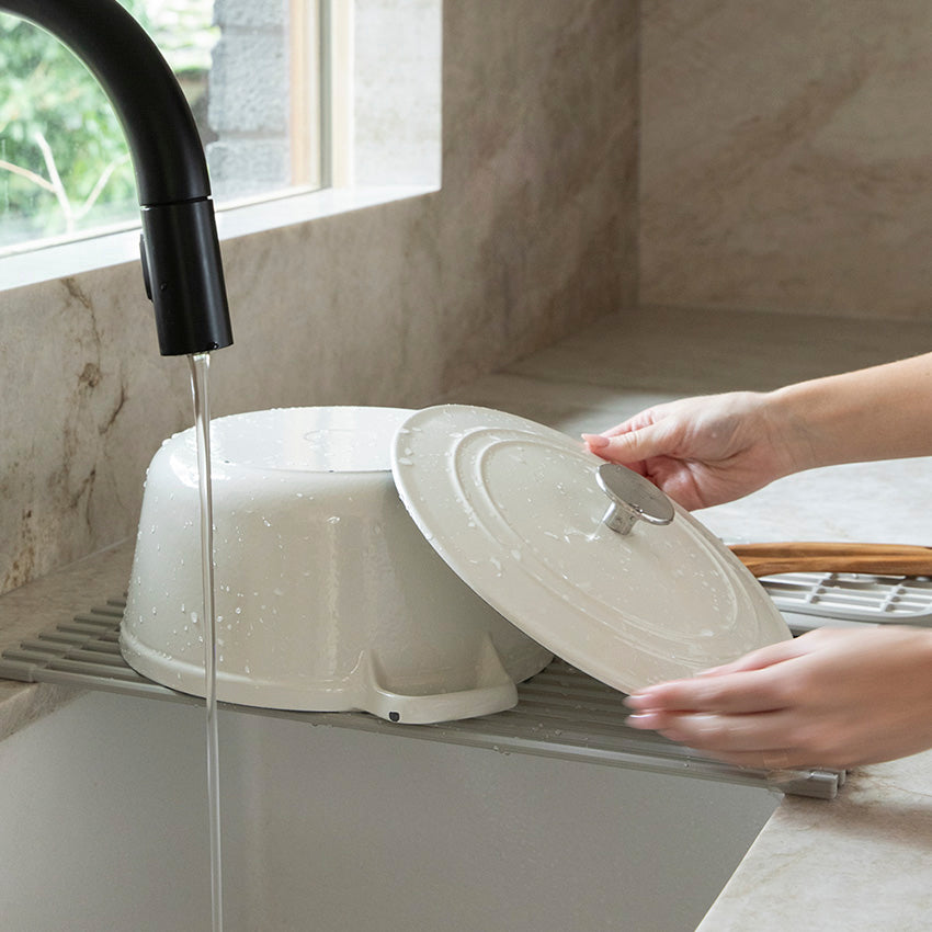 over the sink drainer with heavy cast iron pot being dried