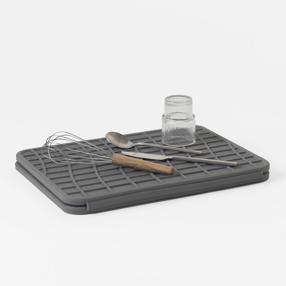 folded dish pad with utensils and glass being dried