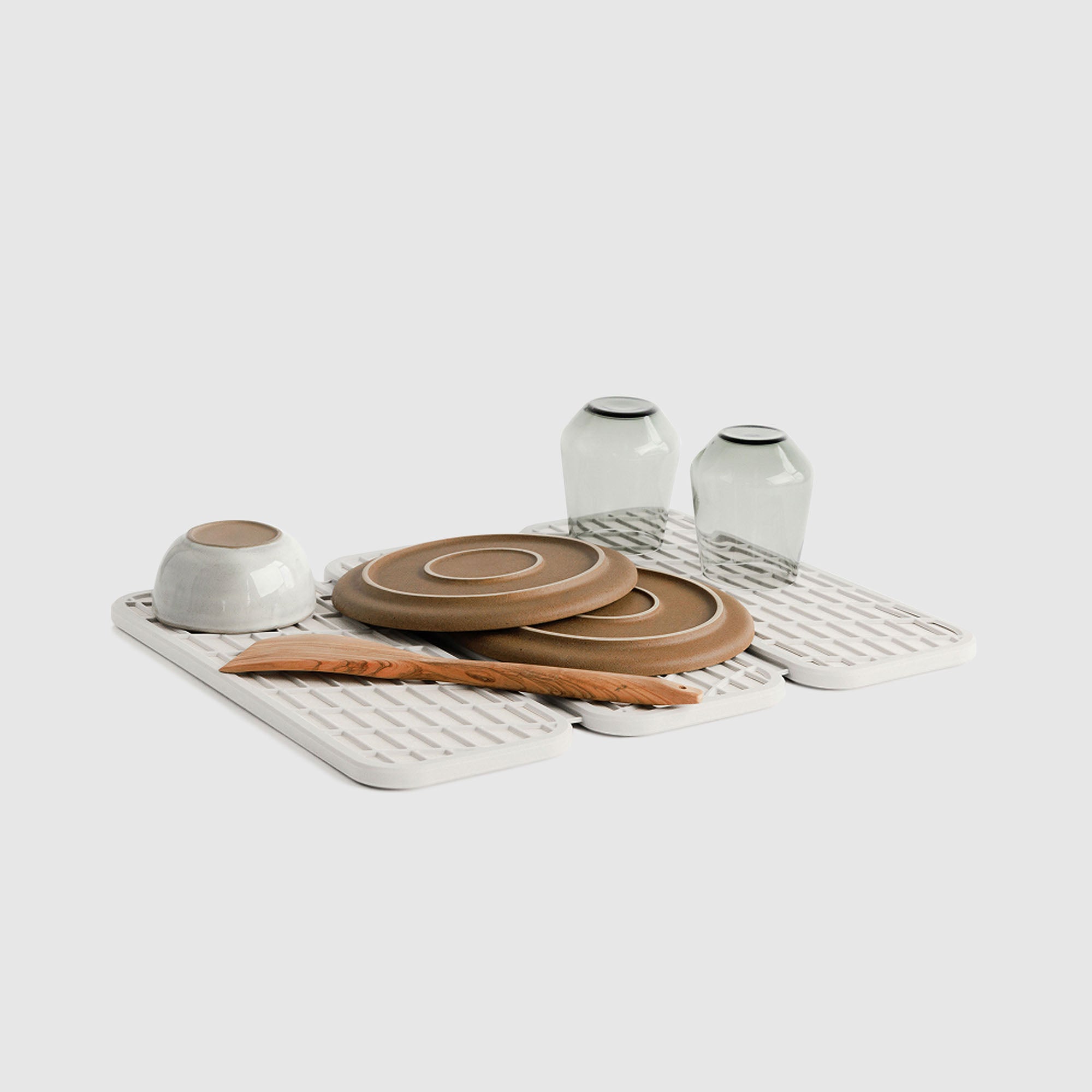 Drift Glacier Dish Pad with plates and glasses on white background.
