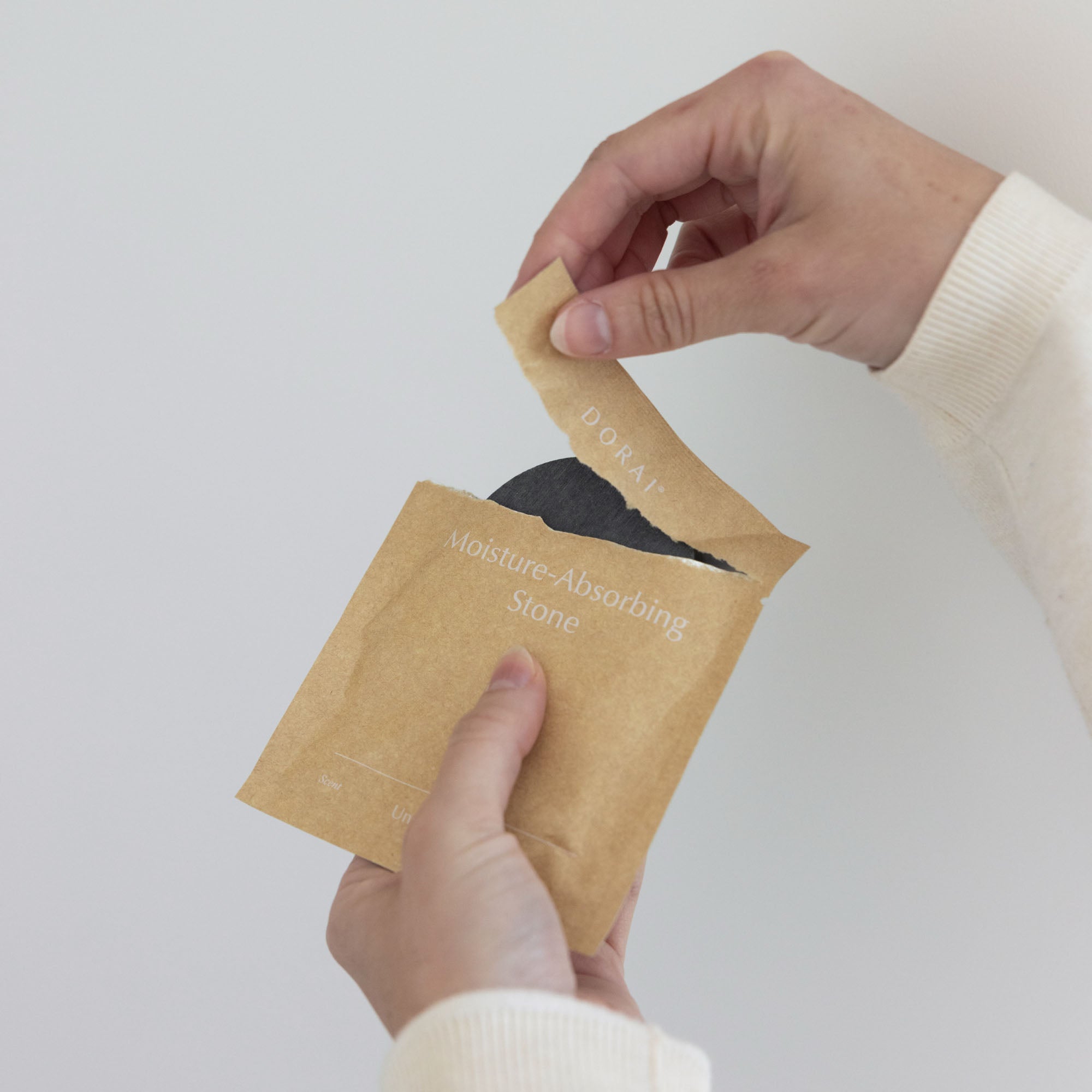 Person opening new unscented quick-drying stone. 