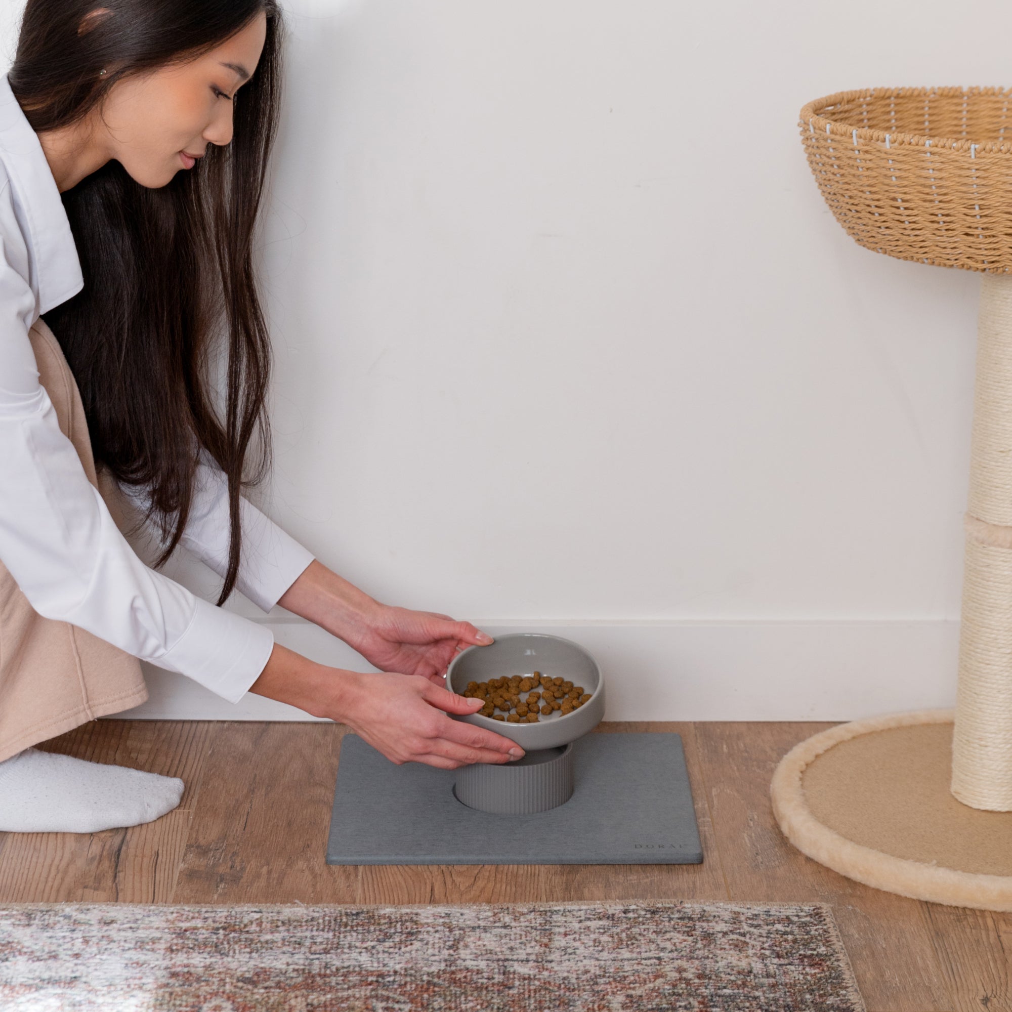 elevated modern ceramic cat bowl being put on top of silicone riser 