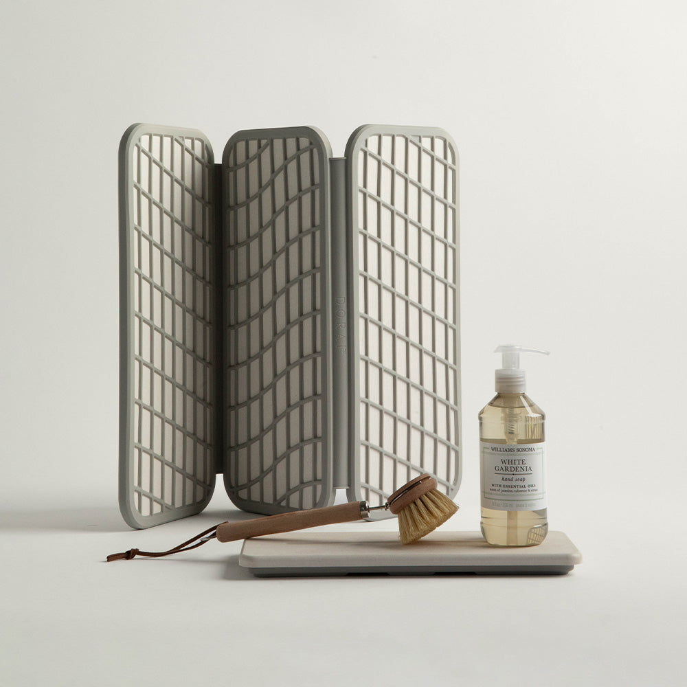 stone dish pad mat being folded with sandstone sink caddy