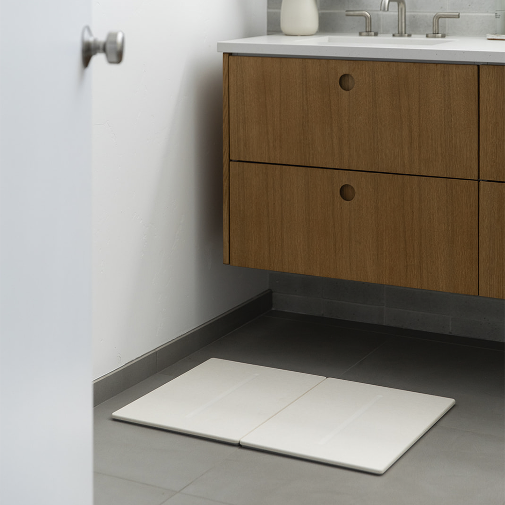bathroom sink with beige bath mat 