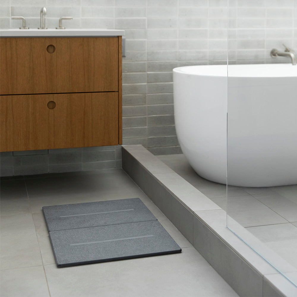 modern bathroom with tub and dark grey bathroom mat