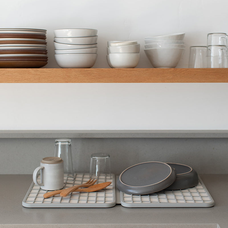 dish drying mat with dishes and glasses being dried 