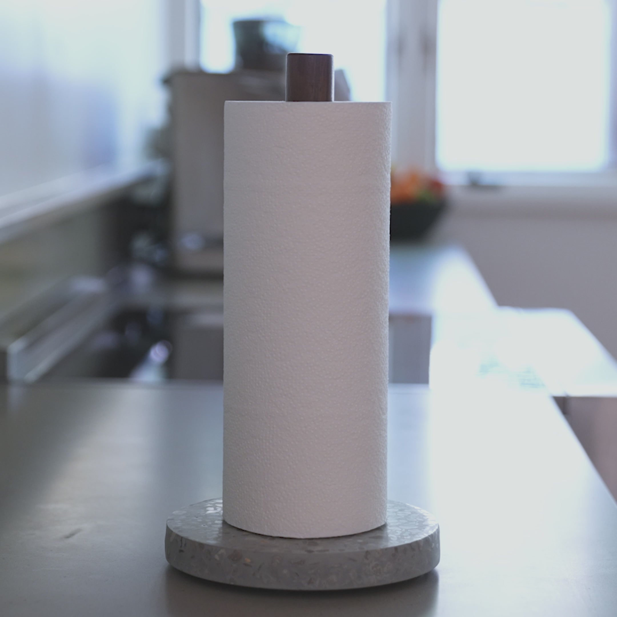 Ripping Basalt Paper Towel Holder with one hand in beautiful kitchen. 