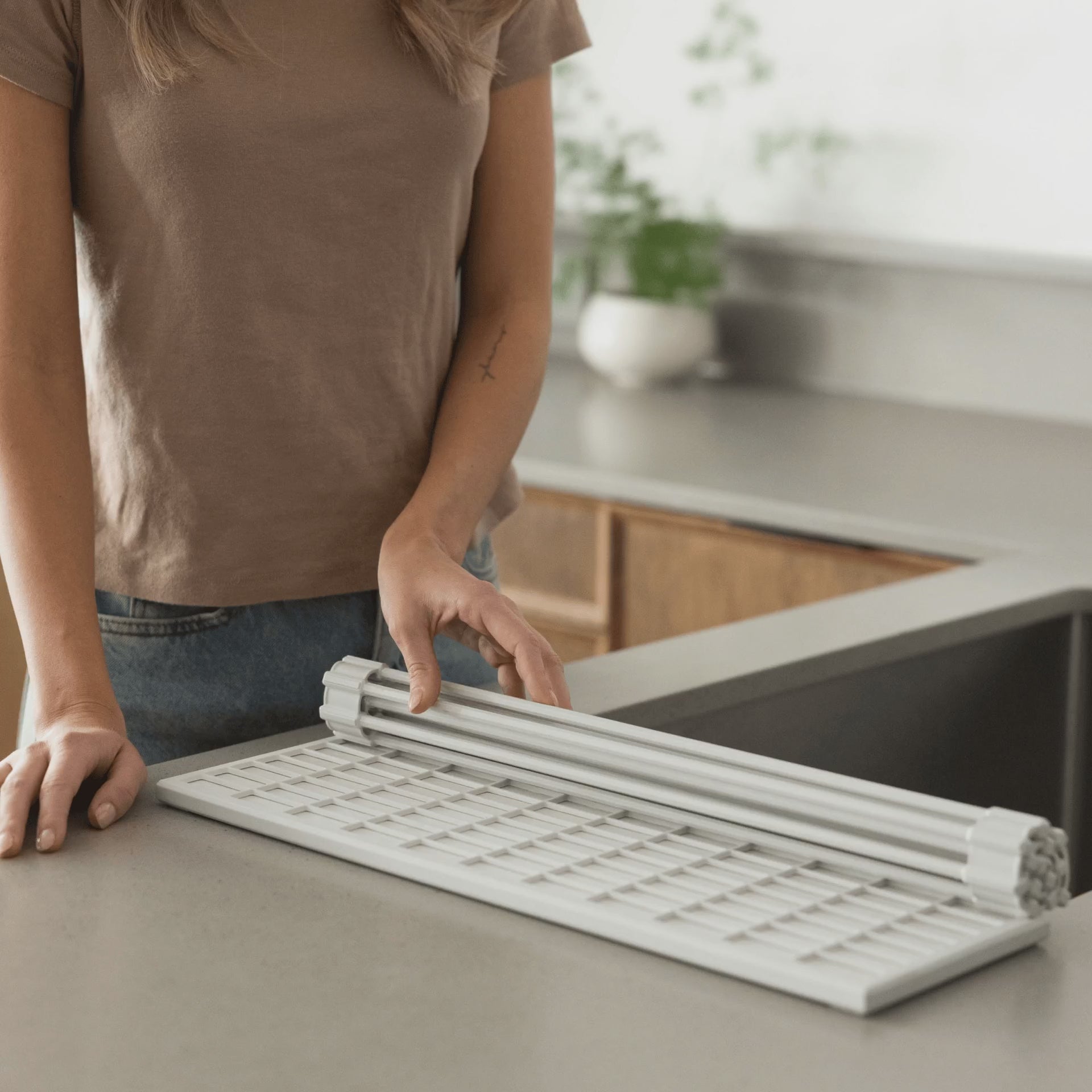 video of woman unrolling a dish pad over her kitchen sink